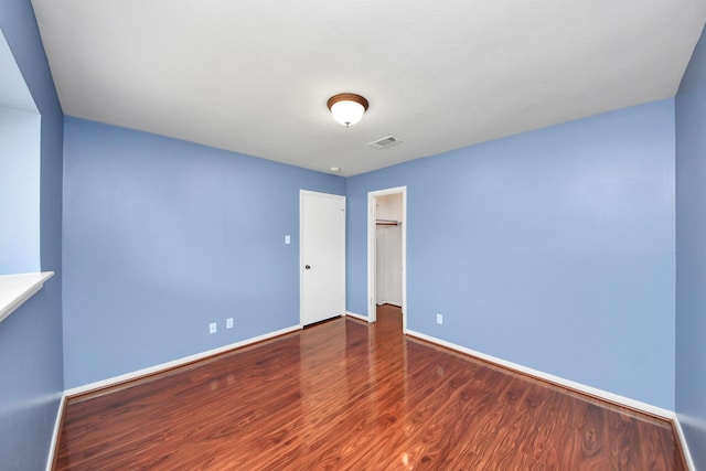 730 Columbia Ln, Deer Park, TX 77536 - unfurnished bedroom with wood finished floors, baseboards, a closet, and a spacious closet