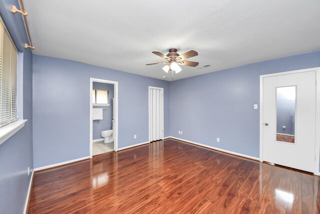 730 Columbia Ln, Deer Park, TX 77536 - unfurnished bedroom with wood finished floors, baseboards, connected bathroom, and ceiling fan