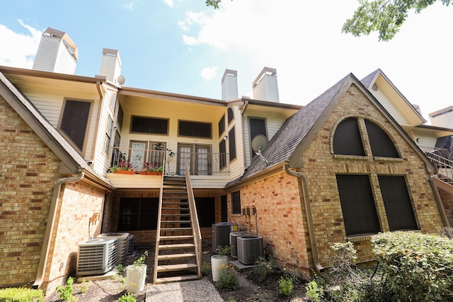 2425 Holly Hall St Unit 149, Houston, TX 77054 - back of house featuring stairway, a chimney, brick siding, and central air condition unit