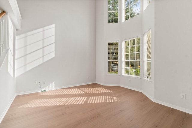 19827 Lajuana Ln, Spring, TX 77388 - unfurnished room with wood finished floors, healthy amount of natural light, baseboards, and a towering ceiling
