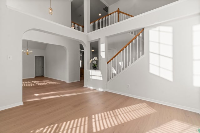19827 Lajuana Ln, Spring, TX 77388 - entryway with arched walkways, wood finished floors, a chandelier, baseboards, and a high ceiling
