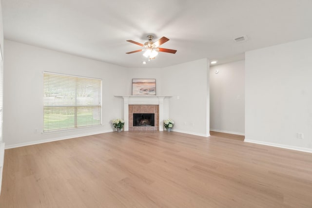 19827 Lajuana Ln, Spring, TX 77388 - unfurnished living room with a ceiling fan, wood finished floors, a tiled fireplace, and baseboards
