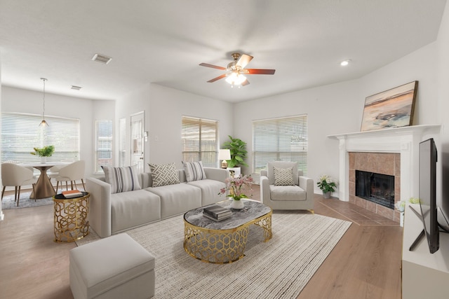 19827 Lajuana Ln, Spring, TX 77388 - living area with wood finished floors, ceiling fan, a tiled fireplace, and recessed lighting