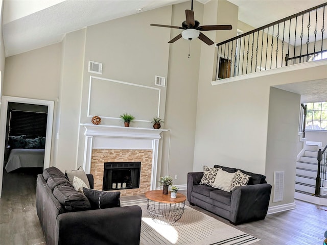 10067 Lazy Meadows Dr, Houston, TX 77064 - living area with high vaulted ceiling, wood finished floors, stairs, ceiling fan, and a stone fireplace