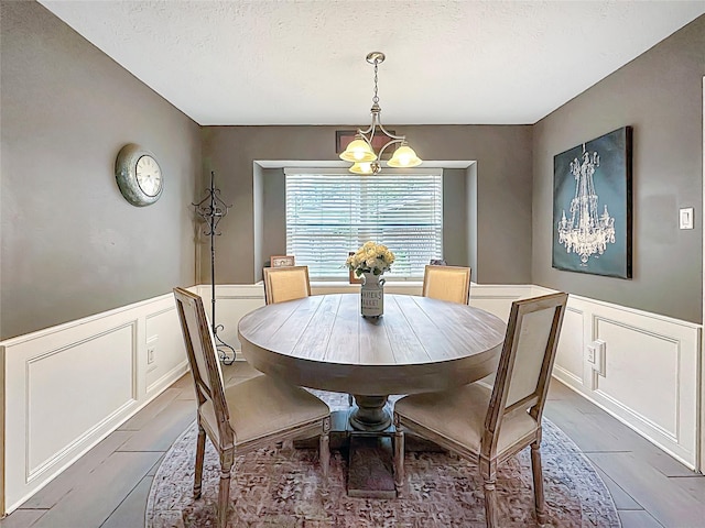 17407 Majestic Forest Dr, Spring, TX 77379 - dining area with a decorative wall, a chandelier, wainscoting, and a textured ceiling