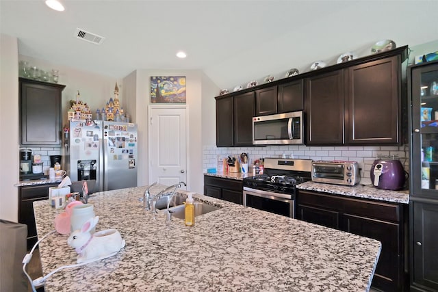 8434 Violet Hills Ln, Rosharon, TX 77583 - kitchen featuring stainless steel appliances, a sink, backsplash, dark brown cabinets, and recessed lighting
