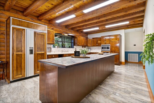 1000 W Polk St, Livingston, TX 77351 - kitchen featuring decorative backsplash, built in appliances, wooden ceiling with exposed beams, a center island, and brown cabinetry