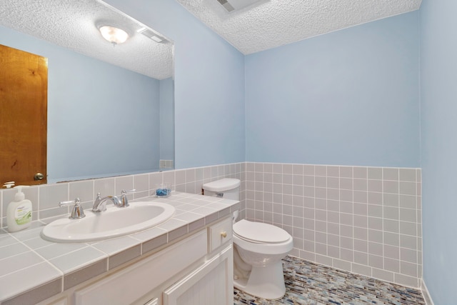 1000 W Polk St, Livingston, TX 77351 - half bathroom featuring a textured ceiling, vanity, and toilet