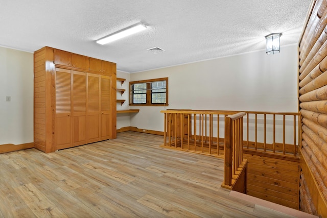1000 W Polk St, Livingston, TX 77351 - spare room with a textured ceiling, light wood-type flooring, baseboards, and ornamental molding