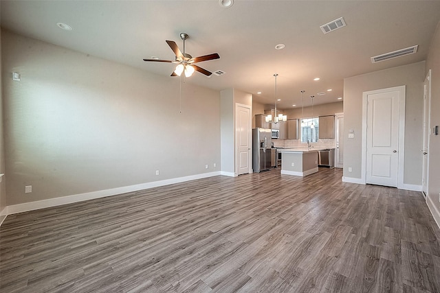 7703 Rainbow Close Ln, Houston, TX 77055 - unfurnished living room with dark wood-style flooring, ceiling fan, a chandelier, baseboards, and recessed lighting