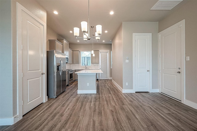 7703 Rainbow Close Ln, Houston, TX 77055 - kitchen featuring appliances with stainless steel finishes, dark wood-style flooring, a chandelier, light countertops, and backsplash