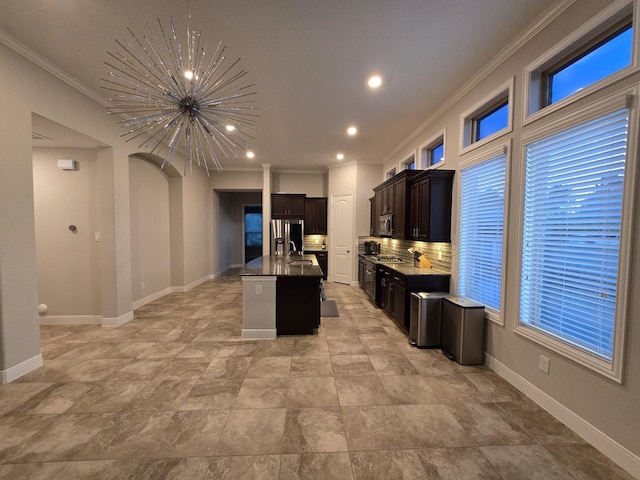 3207 Karleigh Way, Richmond, TX 77406 - kitchen with crown molding, a center island with sink, a chandelier, tasteful backsplash, and baseboards