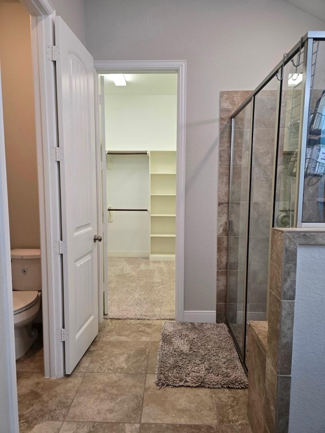 3207 Karleigh Way, Richmond, TX 77406 - bathroom featuring a shower stall, a spacious closet, toilet, and baseboards