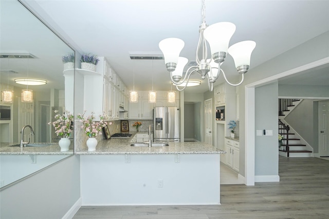 15202 Delbarton Dr, Houston, TX 77083 - kitchen featuring stainless steel fridge with ice dispenser, a sink, a peninsula, and light stone counters