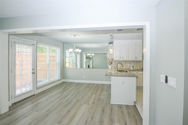 15202 Delbarton Dr, Houston, TX 77083 - kitchen with a sink, light wood finished floors, a chandelier, white cabinets, and backsplash