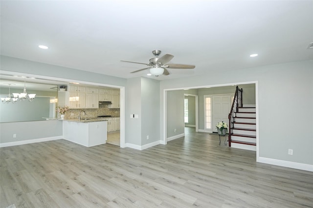 15202 Delbarton Dr, Houston, TX 77083 - unfurnished living room featuring light wood-style floors, stairway, baseboards, and recessed lighting