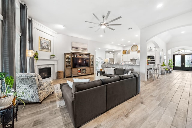 3607 Brook St, Rosharon, TX 77583 - living area featuring a fireplace, arched walkways, a ceiling fan, recessed lighting, and light wood-style floors
