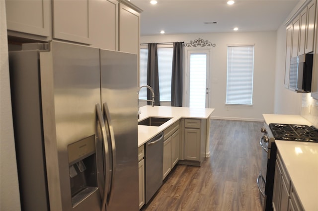673 Royal Arch Dr, Conroe, TX 77304 - kitchen with stainless steel appliances, a sink, dark wood-style flooring, light countertops, and gray cabinetry