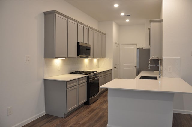 673 Royal Arch Dr, Conroe, TX 77304 - kitchen with stainless steel appliances, gray cabinets, a sink, backsplash, and a peninsula