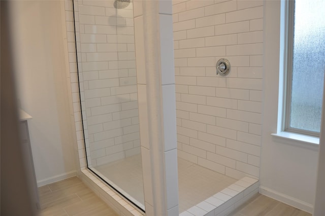 673 Royal Arch Dr, Conroe, TX 77304 - bathroom with tiled shower, baseboards, and wood finished floors