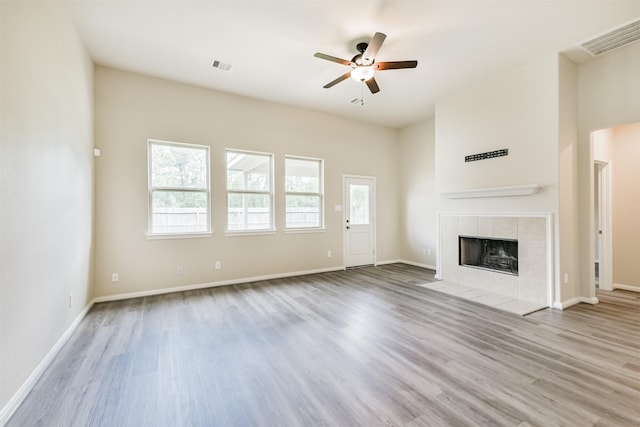 12638 Silver Winter Trl, Houston, TX 77014 - unfurnished living room featuring a ceiling fan, wood finished floors, a tile fireplace, and baseboards
