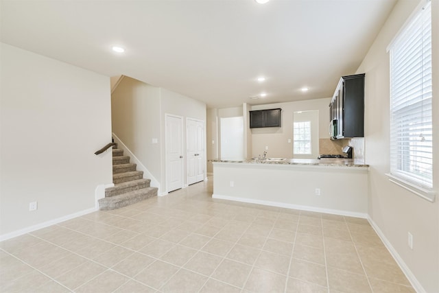 12638 Silver Winter Trl, Houston, TX 77014 - kitchen with a peninsula, stove, recessed lighting, light tile patterned floors, and a sink