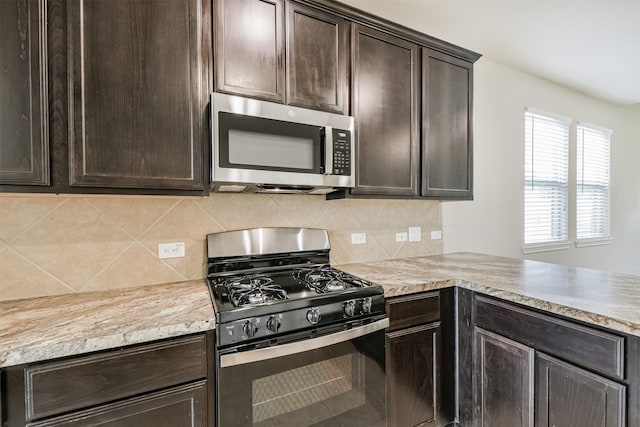 12638 Silver Winter Trl, Houston, TX 77014 - kitchen with stainless steel microwave, black gas stove, dark brown cabinetry, backsplash, and light countertops