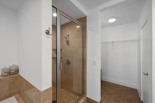 310 Padre Blvd Unit 2305, South Padre Island, TX 78597 - bathroom with a shower stall, a spacious closet, tile patterned floors, and baseboards