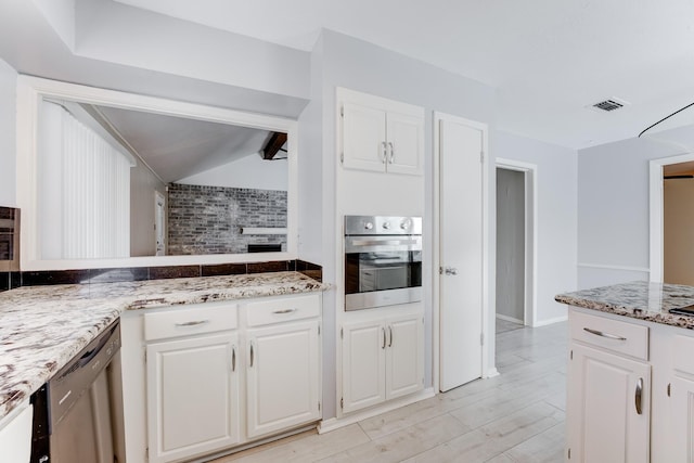 2806 Quail Valley E Dr, Missouri City, TX 77489 - kitchen featuring stainless steel oven, dishwasher, decorative backsplash, white cabinetry, and light stone counters