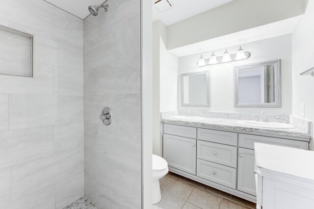 2806 Quail Valley E Dr, Missouri City, TX 77489 - bathroom featuring double vanity, tiled shower, tile patterned flooring, and toilet