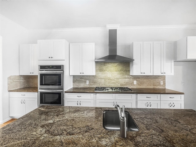 2424 Katy Hockley Cut Off Rd, Katy, TX 77493 - kitchen with wall chimney exhaust hood, stainless steel appliances, dark stone counters, a sink, and white cabinetry
