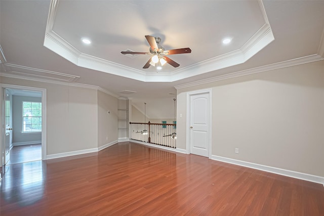 2409 Spears Dr, Humble, TX 77396 - empty room featuring a tray ceiling, ceiling fan, attic access, wood finished floors, and ornamental molding