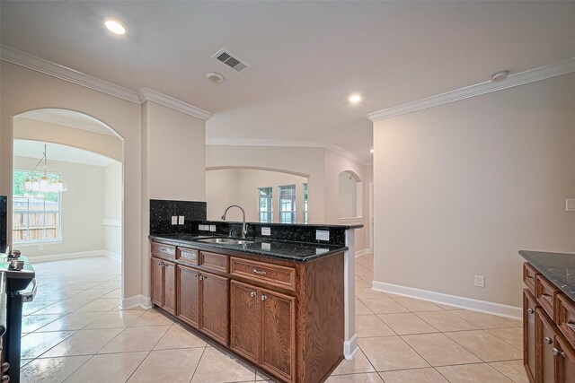 2409 Spears Dr, Humble, TX 77396 - kitchen featuring a sink, crown molding, arched walkways, light tile patterned floors, and recessed lighting