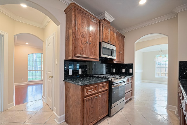 2409 Spears Dr, Humble, TX 77396 - kitchen with appliances with stainless steel finishes, crown molding, light tile patterned floors, tasteful backsplash, and healthy amount of natural light