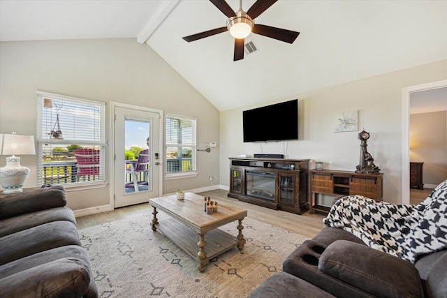 1623 25th St, Dickinson, TX 77539 - living room featuring a ceiling fan, light wood-style floors, beamed ceiling, high vaulted ceiling, and a glass covered fireplace