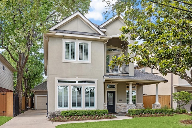 4012 Ruskin St, Houston, TX 77005 - view of front facade with a balcony, stucco siding, concrete driveway, a porch, and a shingled roof