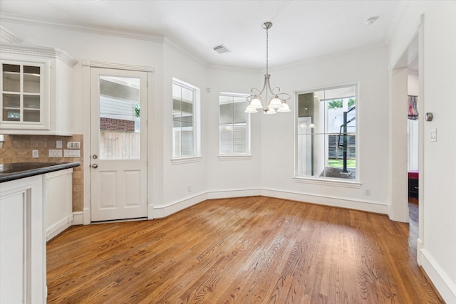 4012 Ruskin St, Houston, TX 77005 - unfurnished dining area featuring light wood-style flooring, a chandelier, baseboards, and ornamental molding
