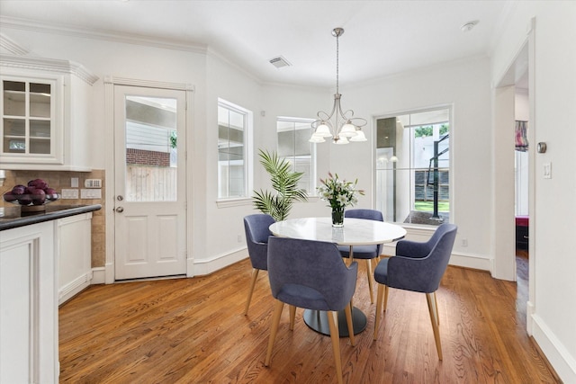 4012 Ruskin St, Houston, TX 77005 - dining room with a chandelier, light wood-style floors, crown molding, and baseboards
