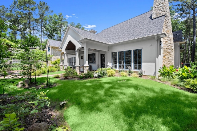 129 Stagecoach Cir, Huntsville, TX 77340 - back of property featuring stucco siding, a shingled roof, a chimney, and a lawn