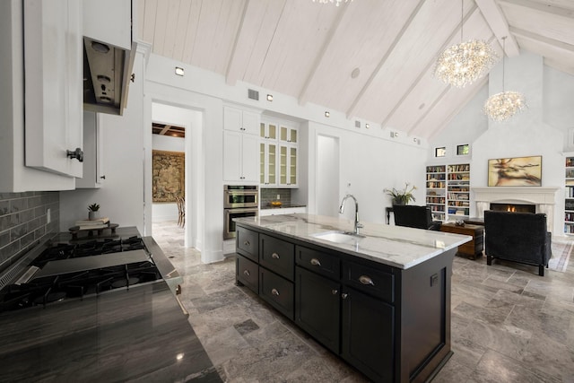 129 Stagecoach Cir, Huntsville, TX 77340 - kitchen featuring a sink, white cabinetry, dark cabinetry, a chandelier, and high vaulted ceiling