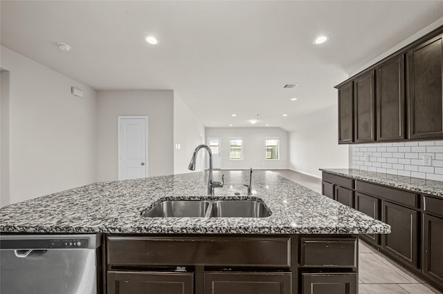 29618 Juntti Park Ct, Katy, TX 77494 - kitchen with dishwasher, a sink, dark brown cabinetry, dark stone counters, and tasteful backsplash