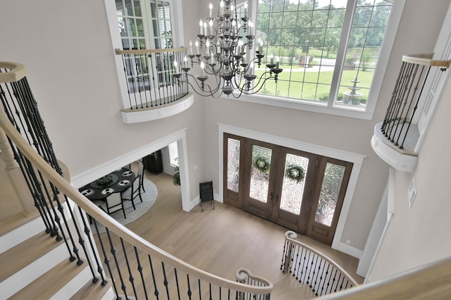 15203 Wildwood Cir, Magnolia, TX 77354 - foyer featuring a towering ceiling, baseboards, french doors, wood finished floors, and stairs