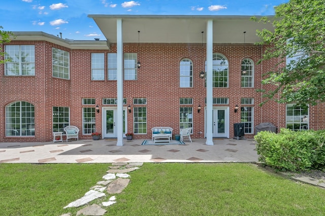 15203 Wildwood Cir, Magnolia, TX 77354 - back of property featuring a lawn, brick siding, and a patio