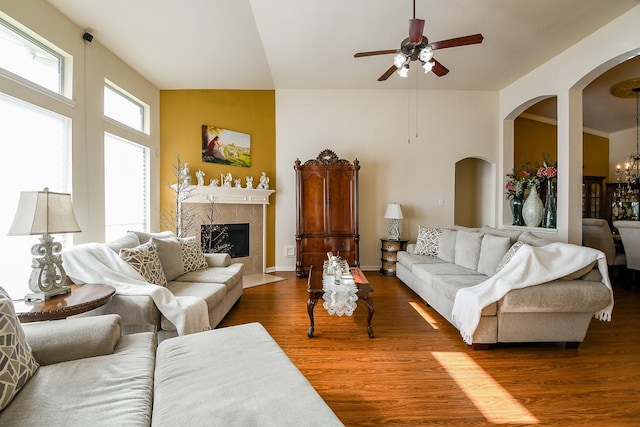 16211 Fleethaven Ln, Houston, TX 77084 - living area with wood finished floors, a ceiling fan, arched walkways, a fireplace, and a chandelier