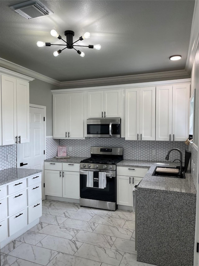 516 Battleview Rd, La Porte, TX 77571 - kitchen featuring appliances with stainless steel finishes, a sink, ornamental molding, light marble finish flooring, and a chandelier
