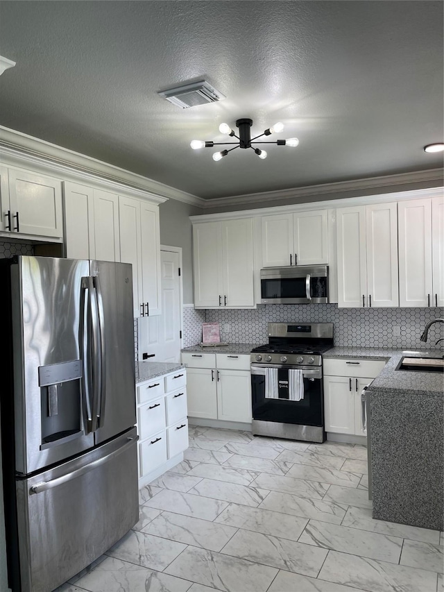 516 Battleview Rd, La Porte, TX 77571 - kitchen featuring appliances with stainless steel finishes, ornamental molding, light marble finish floors, a sink, and white cabinetry