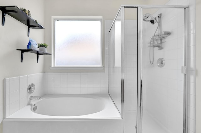 full bathroom featuring a stall shower, a bath, and healthy amount of natural light