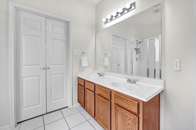 full bath featuring tile patterned floors, a shower stall, and double vanity