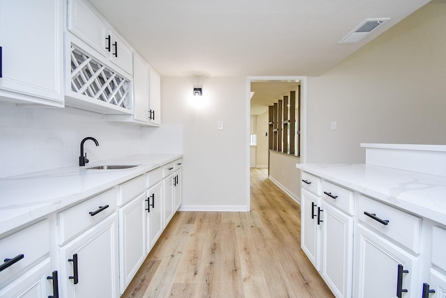 7227 La Granada Dr, Houston, TX 77083 - kitchen with a sink, tasteful backsplash, light wood finished floors, and light stone countertops
