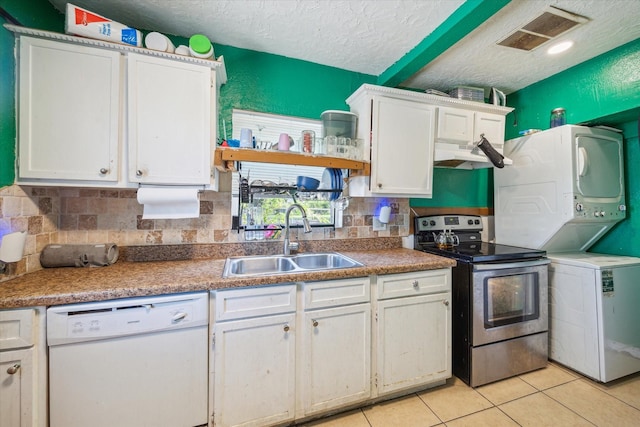 6702 England St, Houston, TX 77021 - kitchen featuring white dishwasher, electric range, estacked washer and dryer, a sink, and white cabinets